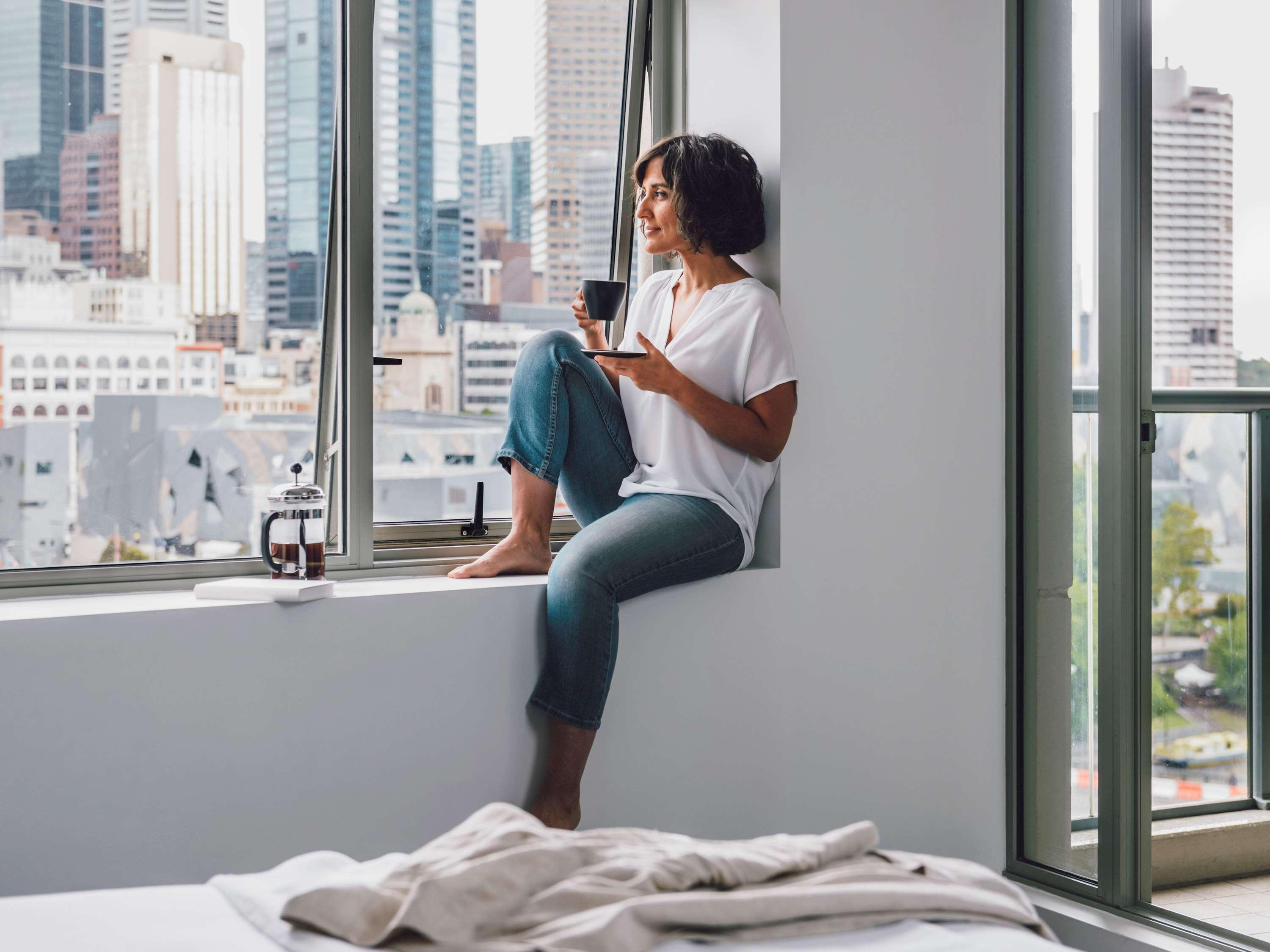 Quay West Suites Melbourne Exterior photo A woman sitting on a windowsill