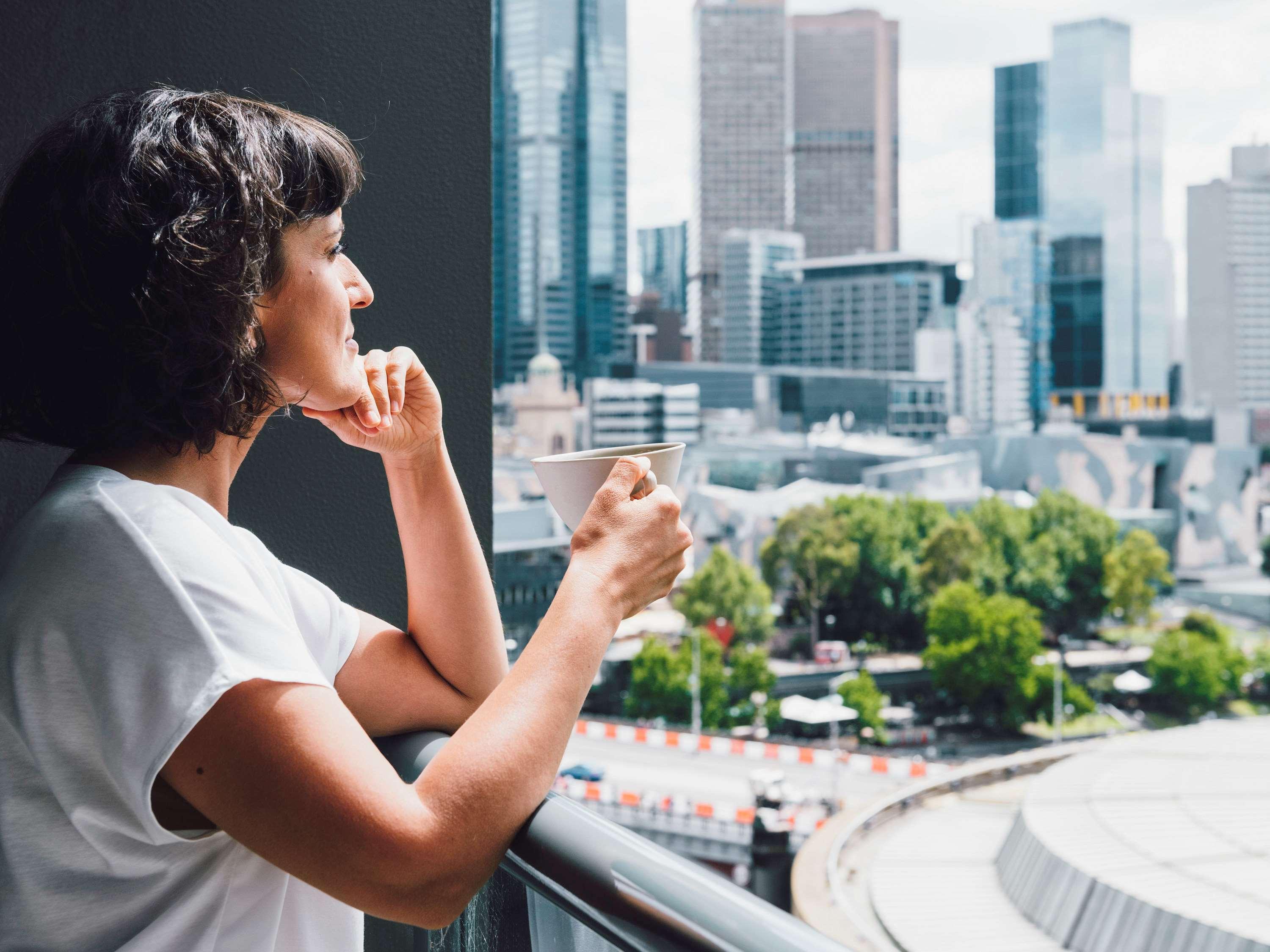 Quay West Suites Melbourne Exterior photo A woman enjoying a cup of coffee